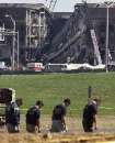 U.S. Federal Investigators (foreground) search for clues near the damaged area of the Pentagon Building as fire fighters and rescue workers continue to battle smoke at the U.S. Military Headquarters outside of Washington, September 12, 2001. The Pentagon and the World Trade Center Buildings in New York City were attacked yesterday after terrorists hijacked commercial jetliners and crashed them into the buildings.                               REUTERS/Larry Downing